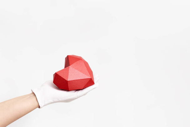 Hand holding red heart on white background. Healht care, love concept. Image for World health day, World heart day. - 写真・画像
