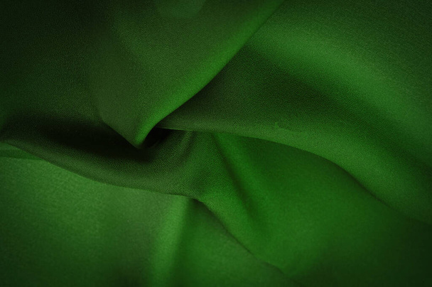 Silk green fabric. Emerald-silk fabric, lightweight silky and comfortable creates a durable silky drape as well as versatility, making it suitable for a wide variety of design applications - Photo, Image
