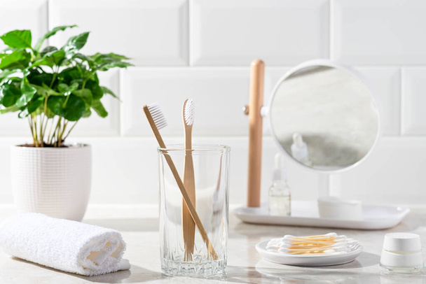 Bathroom accessories. Toothbrushes, mirror, towel, cotton swabs, face cream. - Photo, Image