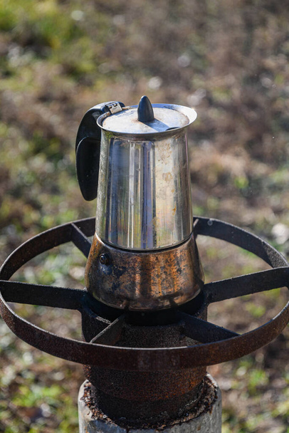 Bahçede, odun yakan bir ocakta gayzer kahve makinesinde kahve yapmak. Güzel bir sonbahar günü. - Fotoğraf, Görsel
