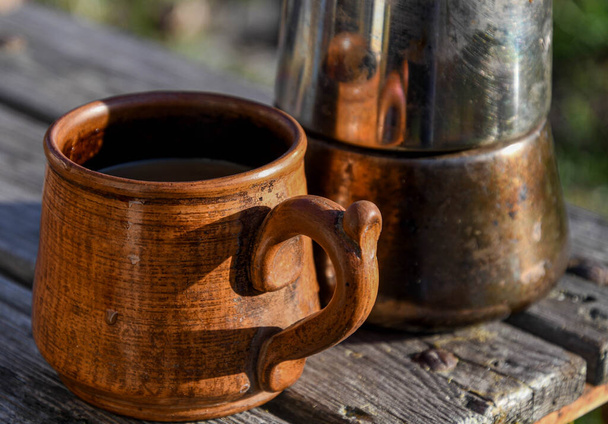  Ceramic cup with coffee outside in the garden prepared in a geyser coffee maker. - Photo, Image