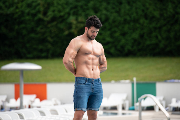 Fashion Portrait Of A Very Muscular Sexy Man In Short Jeans At Swimming Pool - Фото, зображення