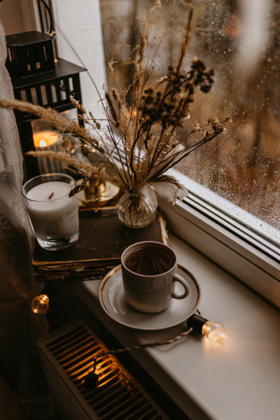 šálek kávy a suché hnědé květy na okně - Fotografie, Obrázek