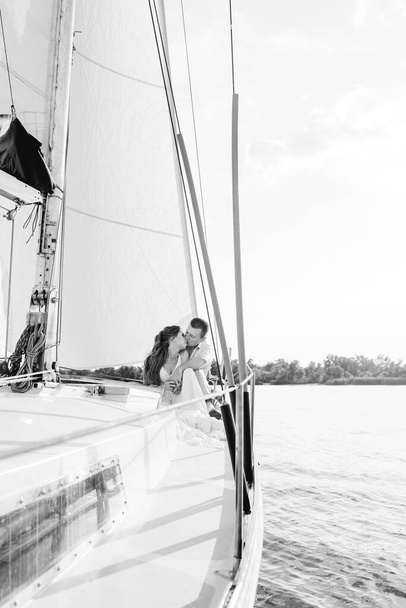 молода пара хлопець і дівчина на білій вітрильній яхті
 - Фото, зображення