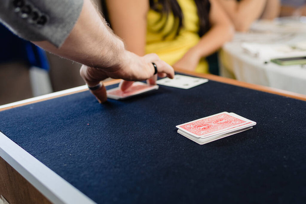 Een goochelaar voert een truc met kaarten gezicht naar beneden op een mat. - Foto, afbeelding