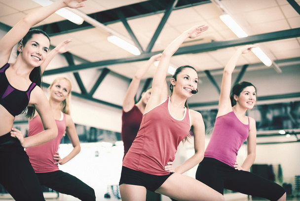 group of smiling people stretching in the gym - Foto, Imagem
