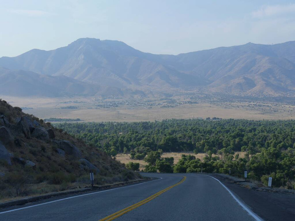 Winding επικλινές δρόμο με μακρινά βουνά στο παρασκήνιο, Kern County, Καλιφόρνια. - Φωτογραφία, εικόνα