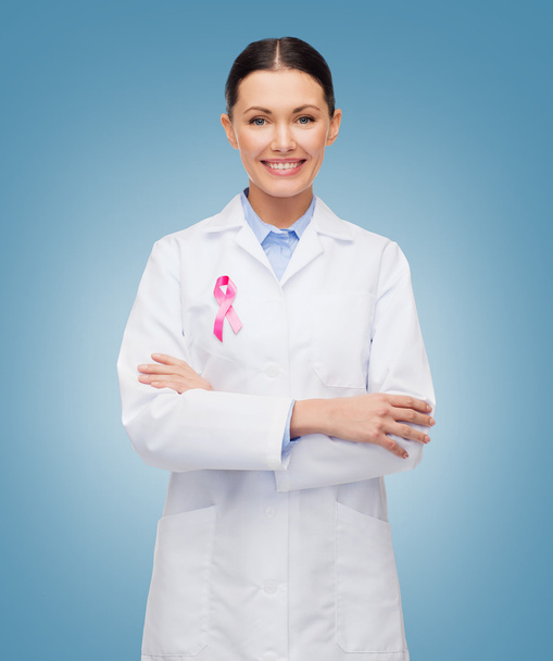 smiling female doctor with cancer awareness ribbon - Photo, image