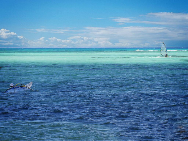 Different hues of blue waters at Micro Beach, Saipan, with windsurfers in view - Photo, Image