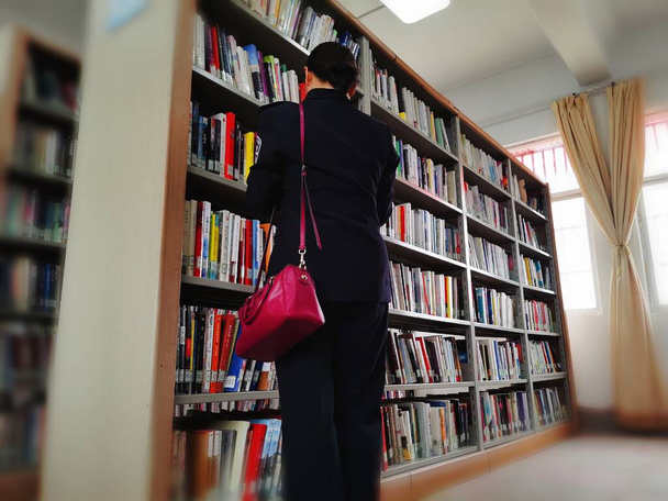 young man with books in library - Foto, imagen