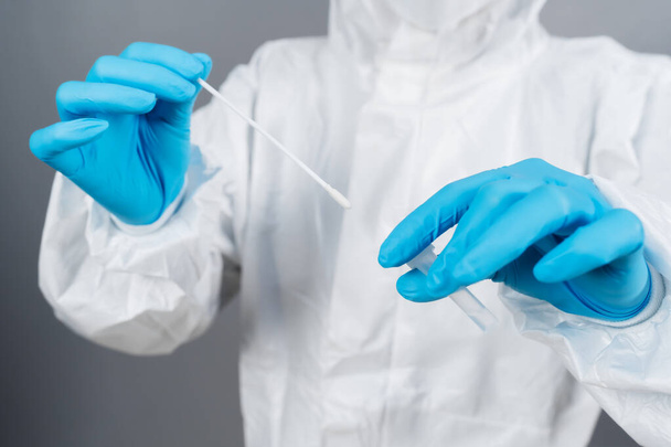 close up doctor in protective suit PPE holding Coronavirus(COVID-19) Nasal swab laboratory test - Foto, afbeelding