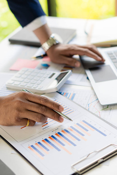 Biznesmen trzymający długopis wskazujący na analizę papieru, wykresów finansowych i wykresów na stole. i planowania inwestycji dla biznesu i pionowe zbliżenie zapasów zdjęć - Zdjęcie, obraz