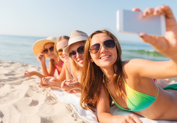 group of smiling women with smartphone on beach - Photo, image