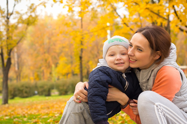 nuori äiti lastensa kanssa puistossa syksyllä
 - Valokuva, kuva