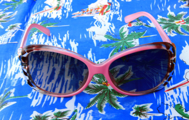 Womans sunglasses laying on the beach summertime - Фото, изображение