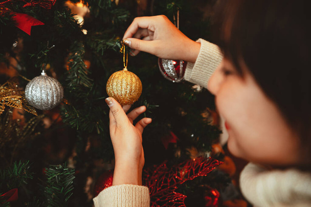 έννοια χειμερινές διακοπές, Ευτυχισμένη γυναίκα Διακόσμηση χριστουγεννιάτικο δέντρο για τον εορτασμό της Πρωτοχρονιάς - Φωτογραφία, εικόνα