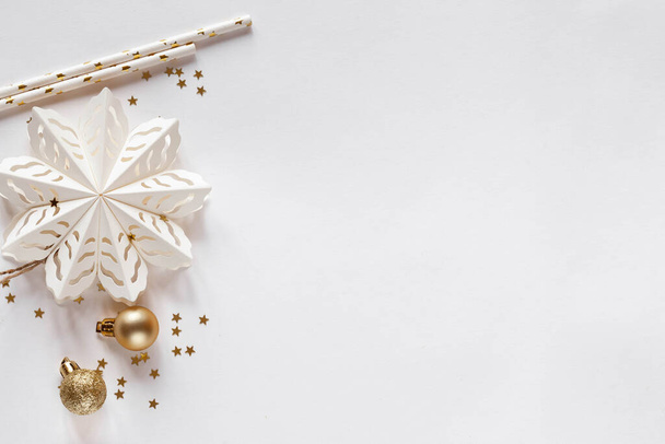 White Christmas background with golden balls, stars and paper snowflake, top view - Fotó, kép