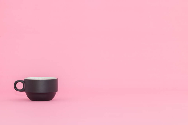 A black coffee cup on the pink background with copy space. - Φωτογραφία, εικόνα