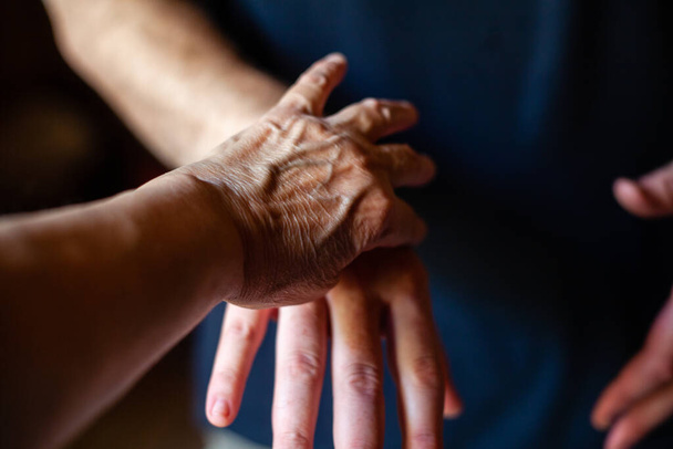 An elderly Caucasian hand holding young man hand - Foto, Imagem