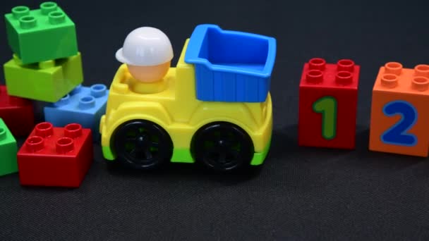 Camión de juguete para niños y bloques de construcción de diferentes colores y números uno a cuatro también son visables. - Metraje, vídeo