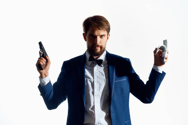man in a suit with gun  light background. High quality photo - 写真・画像