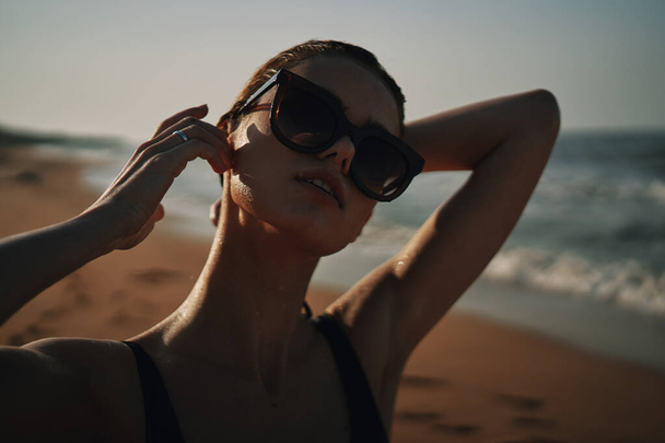 Cheerful woman black swimsuit ocean nature summer tan - Foto, imagen
