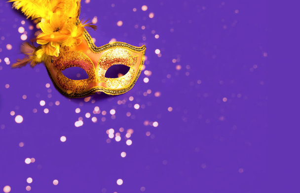 Máscara de carnaval dourado em fundo roxo com brilhos. Efeito desfocado. Conceito de Mardi Gras. Espaço de cópia - Foto, Imagem
