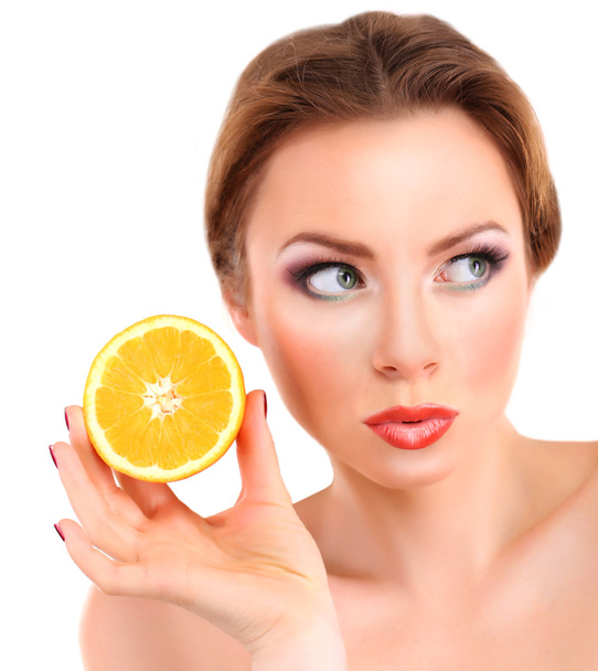 Beautiful young woman with bright make-up, holding orange, isolated on white - Foto, immagini