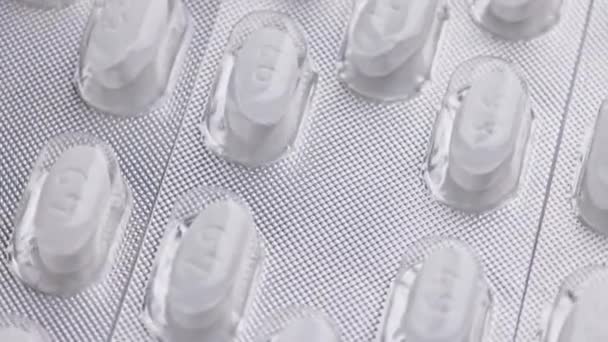 bílá tableta oválné tablety blistry close-up smyčka točení nebo rotující makro pozadí - Záběry, video