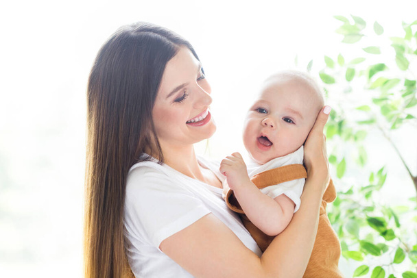Portrait of attractive kind cheerful girl carrying first baby staying safe at light white home flat house indoors - Φωτογραφία, εικόνα