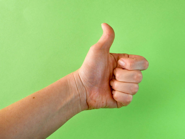 Pulgares hacia arriba signo gesto de la mano en la pantalla verde. Simbolo de aprobación como emoción positiva. Primer plano. - Foto, Imagen