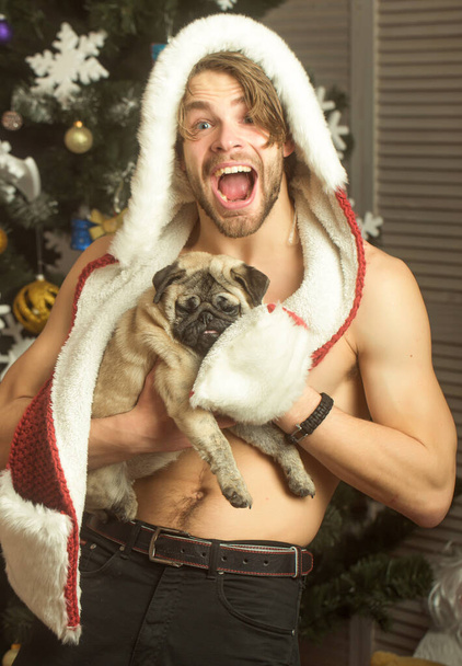 Funny guy, sexy man with happy face with dog in hand. Gay with small puppy dog - Photo, Image