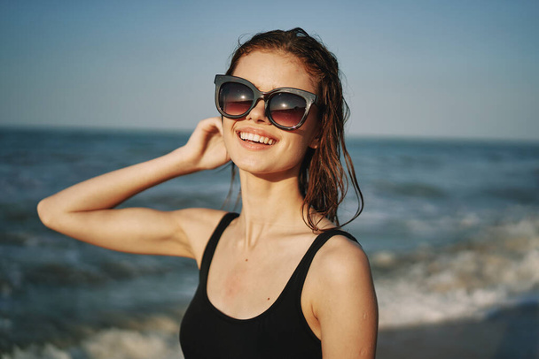 cheerful woman in black swimsuit sunglasses ocean travel - Photo, image
