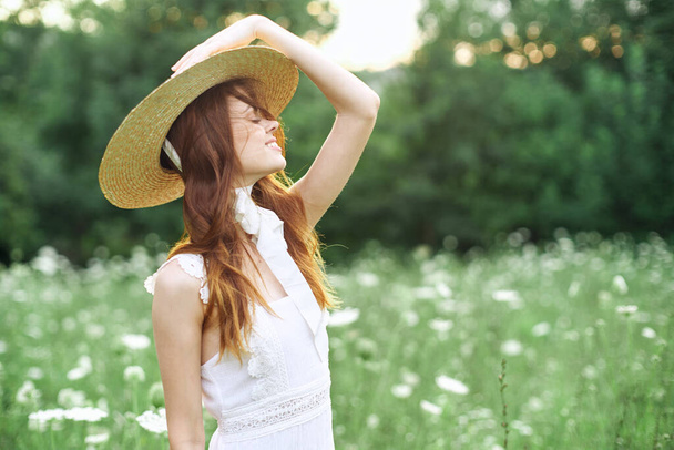 весела жінка в білій сукні на природі квіти ходять
 - Фото, зображення