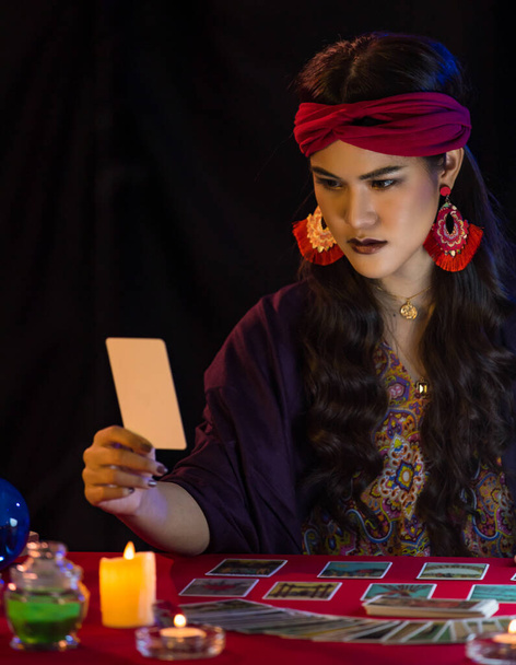 暗い部屋で魔法のセッション中にテーブルの上にタロットカードで未来を読むアジアの女性 - 写真・画像