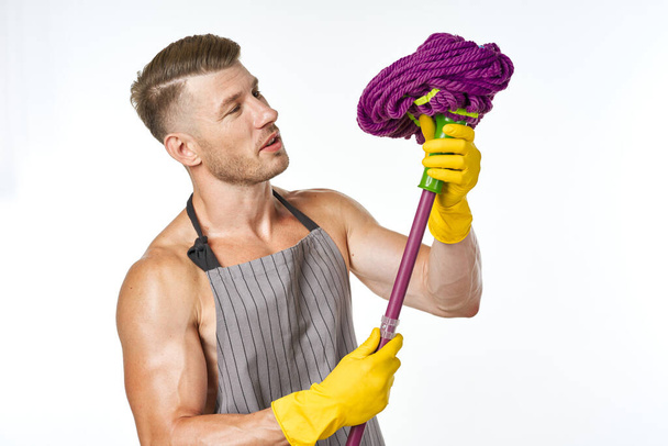 sporty man in aprons with a mop cleaning service - Foto, afbeelding