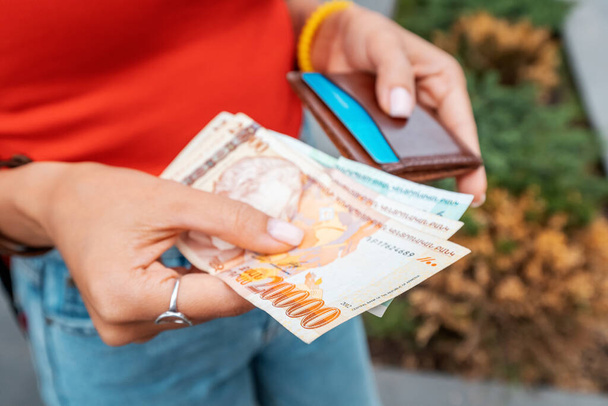 La mujer sacó los billetes de Dram armenios y los tiene en sus manos, de cerca. Tipos de cambio de efectivo y concepto de inflación monetaria - Foto, Imagen