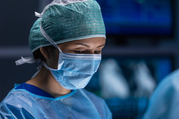 Multiraciale team van professionele chirurgen voert de chirurgische ingreep in een modern ziekenhuis. Artsen proberen de patiënt te redden. Geneeskunde, gezondheid, cardiologie en transplantatie. - Foto, afbeelding