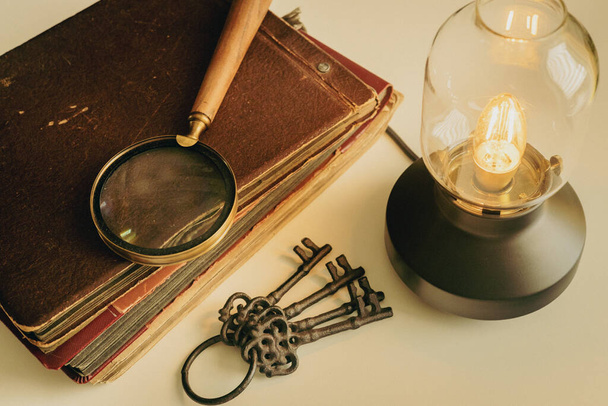Old photo albums, vintage glowing lamp, Keychain, The concept of searching for answers to historical riddles or family memories and souvenirs  - Photo, Image