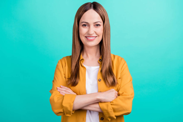 Photo of confident pretty young woman dressed yellow shirt smiling arms crossed isolated teal color background - Valokuva, kuva