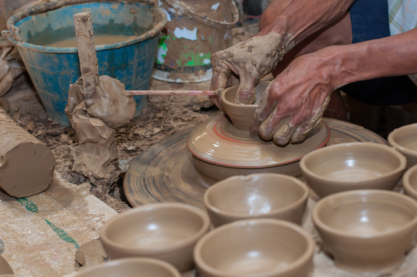 ein Mann formt Keramik, während sie sich auf einem Rad dreht - Foto, Bild