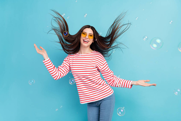 Photo of funky brunette hairdo young lady disco with bubbles wear eyewear red shirt isolated on blue color background - Foto, Imagem