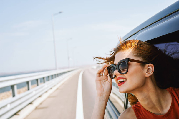 pretty woman in sunglasses rides in a travel car - Foto, Imagen