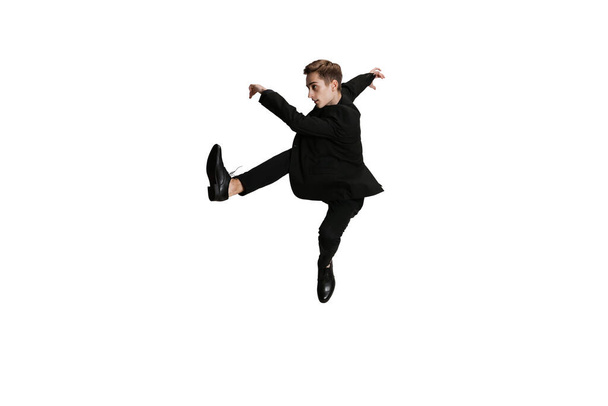Young man in black business suit dancing isolated on white background. Art, motion, action, flexibility, inspiration concept. - Fotografie, Obrázek