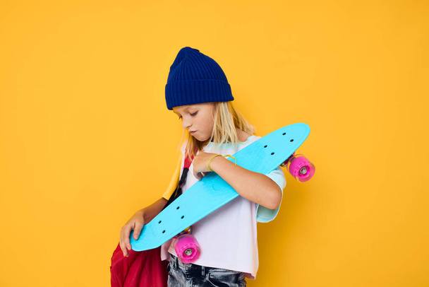 έφηβος σε ένα λευκό t-shirt θέτουν με ένα skateboard στο χέρι έννοια του τρόπου ζωής της παιδικής ηλικίας - Φωτογραφία, εικόνα