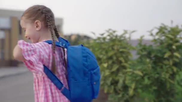 маленька весела дівчинка біжить в школу з рюкзаком на плечах, щаслива дитина поспішає на перший урок, дитина отримає початкову дошкільну освіту, дитина отримає нові знання в класі
 - Кадри, відео