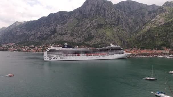Drone uitzicht op een enorme witte cruiseschip bij de kust van de stad Kotor - Video