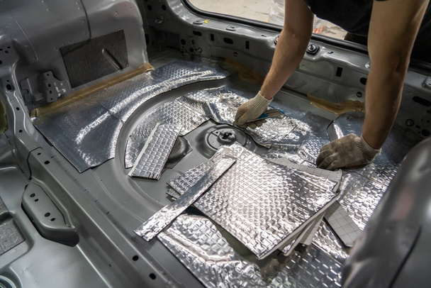 Proces van de installatie van geluidsisolatie materiaal aan de binnenkant van de auto. Automatische geluidsisolatie - Foto, afbeelding