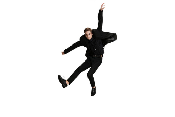 Full-length portriat of young man in black business suit dancing isolated on white background. Art, motion, action - Foto, immagini