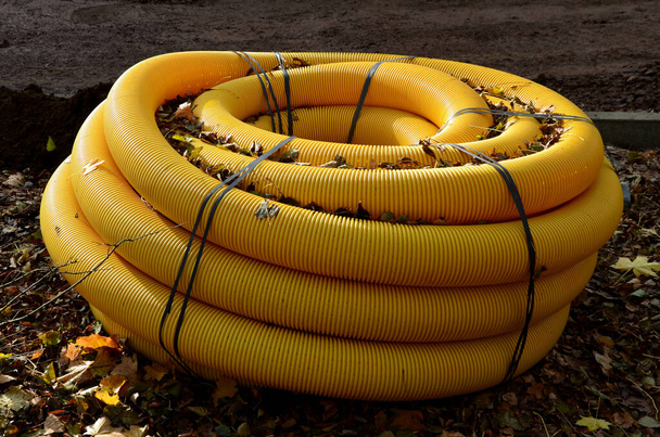 rol, club, grote geel geperforeerde slang, die wordt gebruikt in de bouw als drainagewater. landschapsarchitecten genieten ervan op ontvochtigende tuinen en parken, aan keerwanden. - Foto, afbeelding